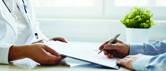 Physician holding a clipboard for a patient's signature